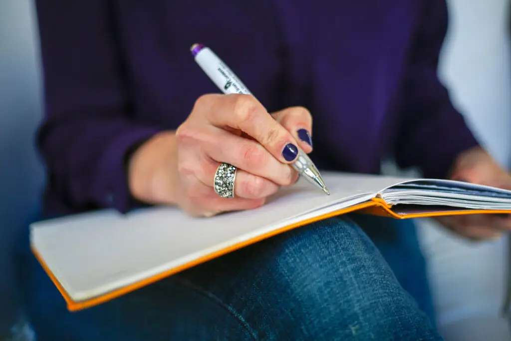 Persona escribiendo en un cuaderno, proceso creativo
